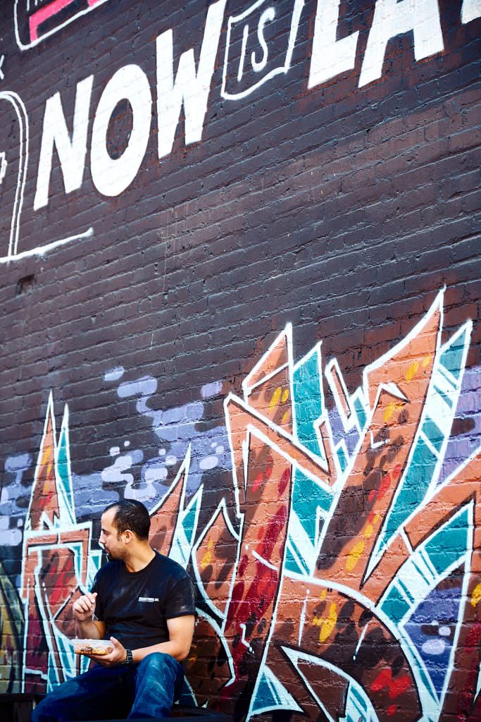 Ouvrier ayant sa pause de déjeuner au pied d'un mur coloré - Seattle, WA - USA
